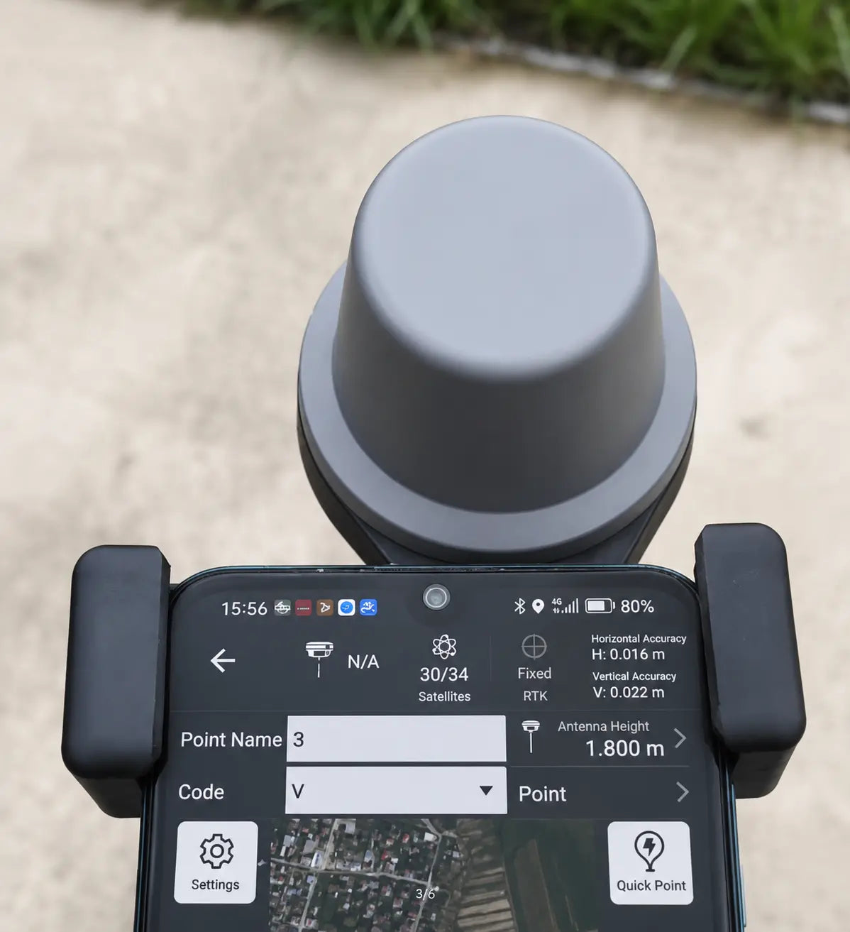 RTK mobile phone holder with clamp grips and screen visible on a phone