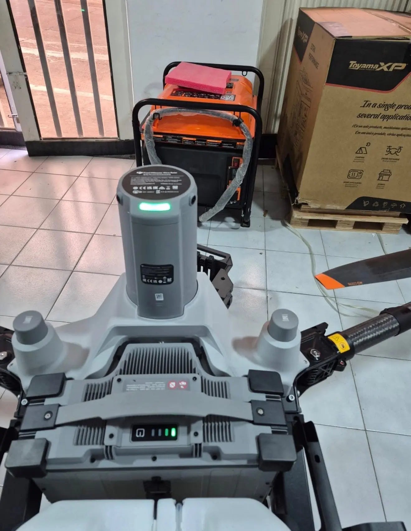 White agricultural sprayer drone base with controls and glowing indicator lights
