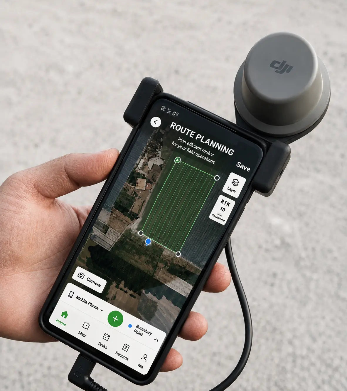 Mobile phone holder with clamp and round RTK module, held in hand with phone