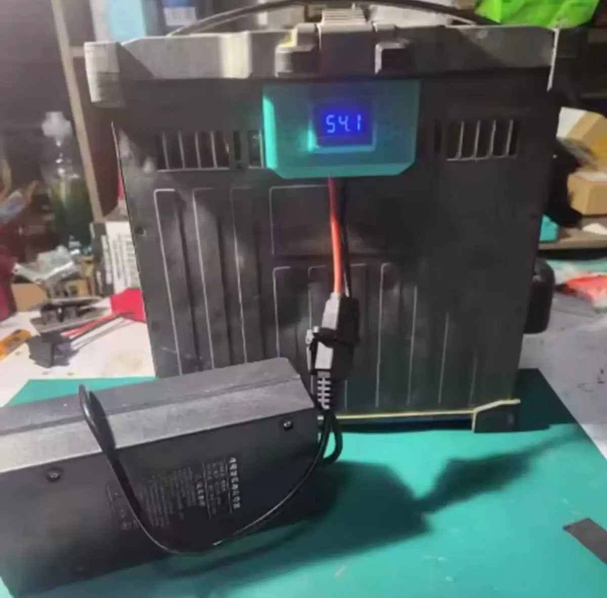 DJI battery slow charger with LCD display and connected charging cable, black housing