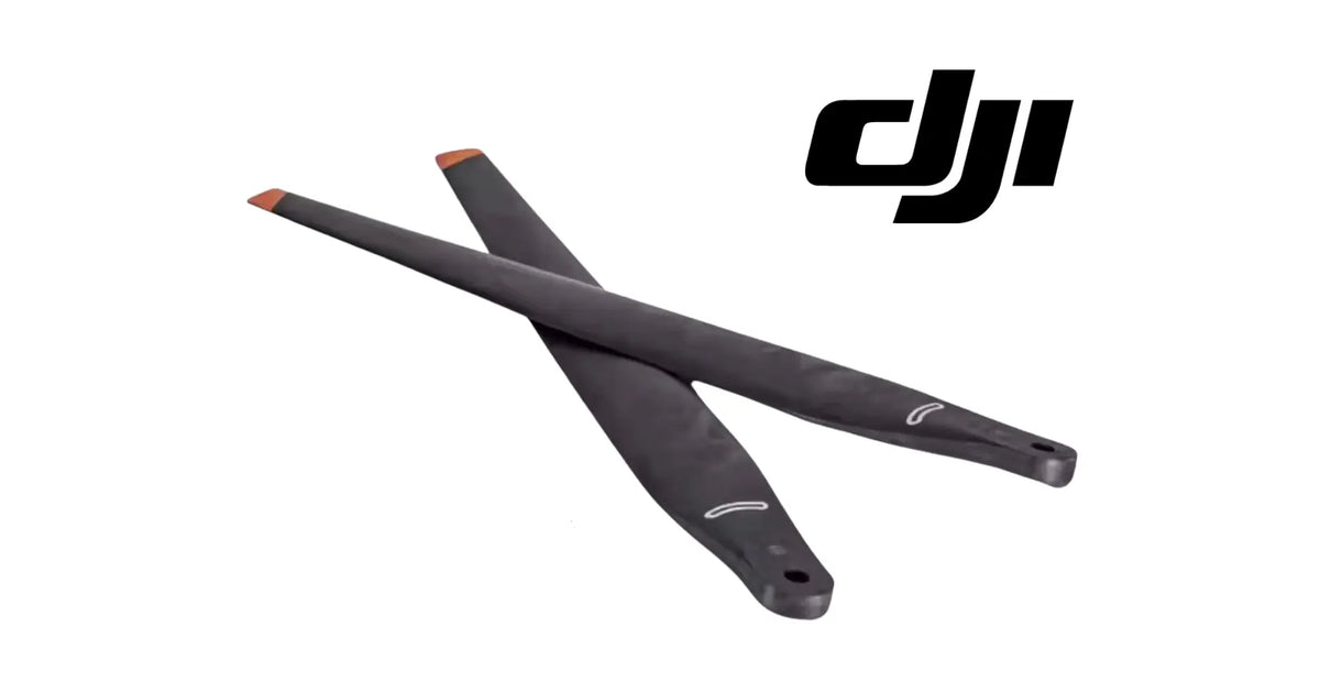 Pair of black drone propellers with orange tips, one blade angled over another