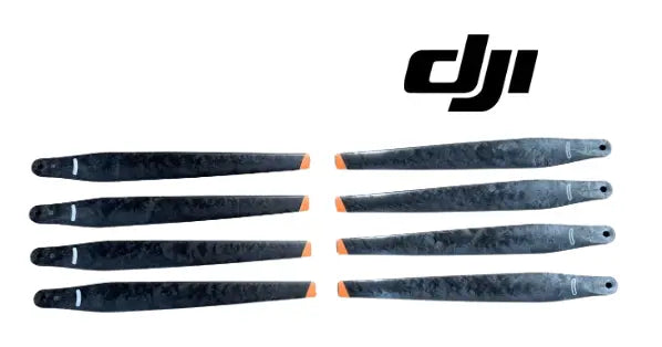 Set of 8 black drone propellers with orange tip accents, spread in two rows