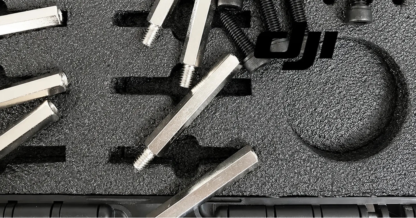 DJI bearing tool set pieces on foam insert, including metal rods and spacers