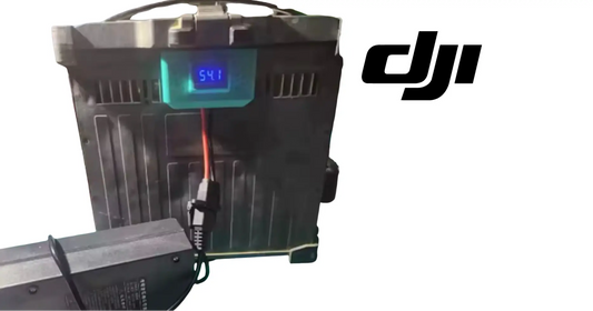 DJI battery slow charger with LCD showing 54 and two cables, black rack housing