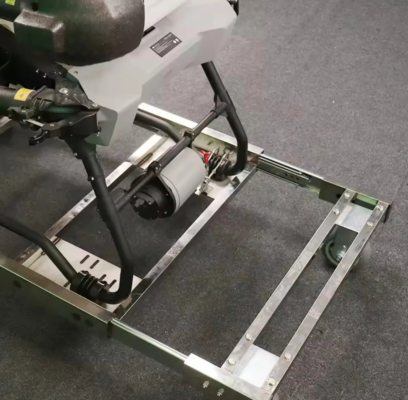 Metal drone transfer cart with mounting frame and actuator arm, green accents.